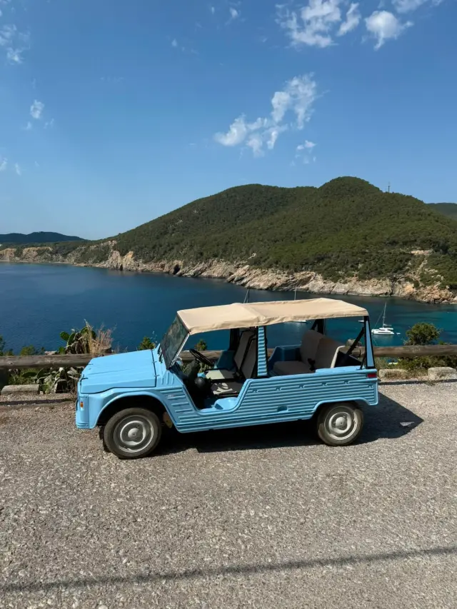 Light blue Citroën Mehari electric tour at Ibiza coastal bay overlook with Mediterranean sea — Retro Rides